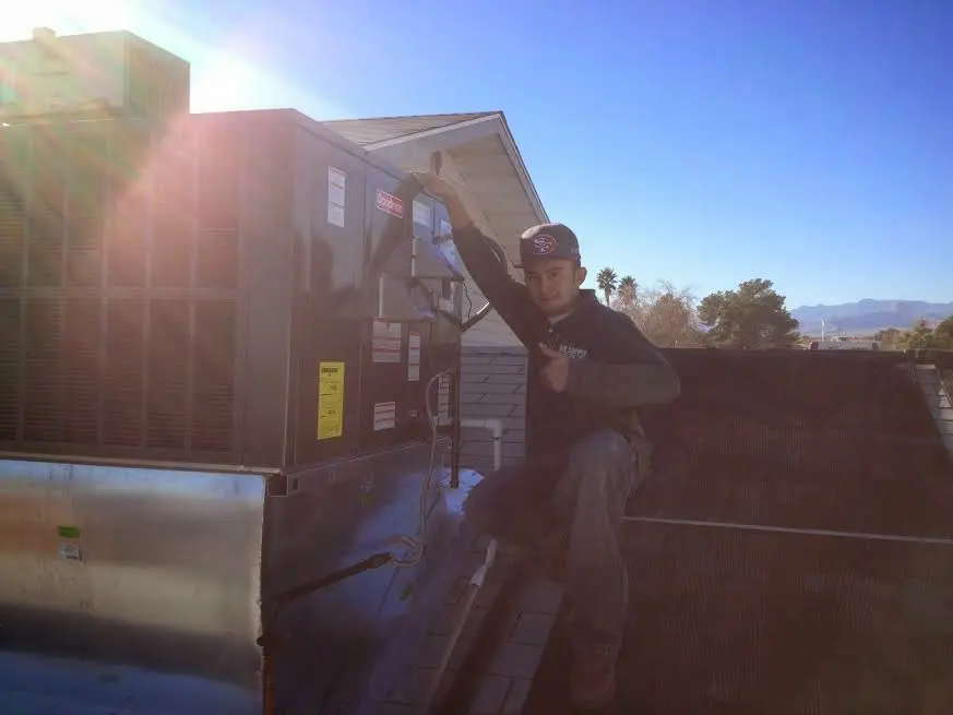 HVAC technician performing Air Duct Cleaning on a rooftop unit in Orland Park